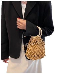 Minimalist straw bucket bag with wooden ring handles and woven drawstring liner