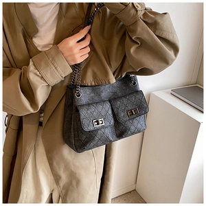 Detail of grey quilted chain bag with double pockets and vintage silver twist locks