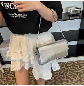Détail du sac à bandoulière argenté avec texture peau de serpent et fini métallique