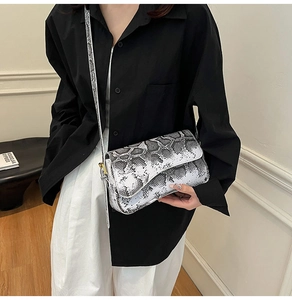 Gros plan du sac selle en peau de serpent noir et blanc avec boucle métallique