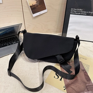 Minimalist black messenger bag with adjustable strap and buckle closure for casual wear