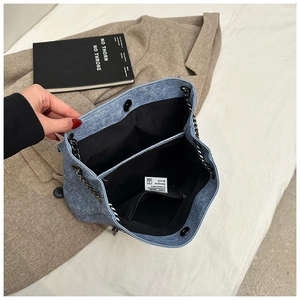Top view of blue denim tote bag interior showing black lining and zip pocket detail
