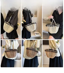 Detail of hand-woven straw crossbody bag with black fringe trim and drawstring closure