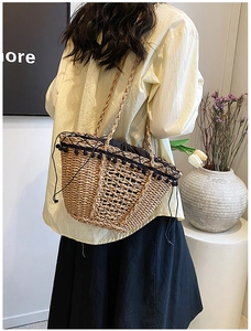 Detail of straw bucket bag with black pom-pom trim and drawstring lining for summer