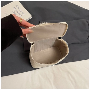 Detail view of the cream quilted chain bag interior with silver zipper and spacious lining