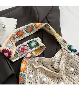 Details einer Häkel-Schultertasche mit Perlen und buntem Blumen-Trageriemen