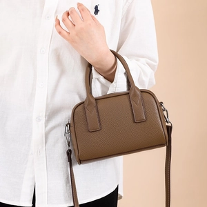 Retro brown lychee leather bowling bag with top handles and shoulder strap shown on model