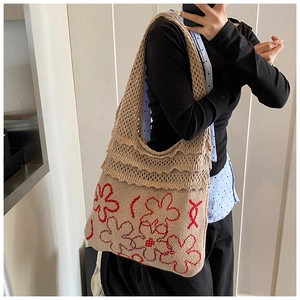 Detail shot of oversized knitted tote bag with red flower pattern and soft texture