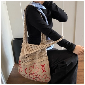 Detail of beige knit tote bag featuring red flower pattern and mesh crochet design