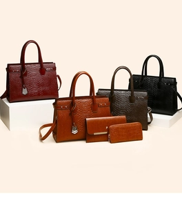 Close-up of crocodile texture leather handbags and matching wallets in classic colors