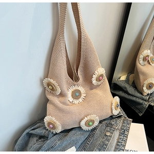 Detailed knit texture and 3D floral appliqués with colorful beads on a beige tote bag