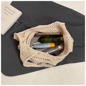 Close-up of beige knitted crochet tote bag showing hollow structure and daily essentials
