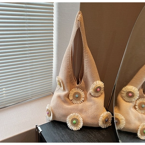 Detail of beige knit hobo bag featuring 3D floral appliques and colorful bead accents