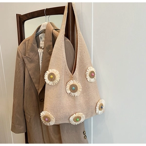 Close-up of hand-knitted beige tote bag featuring 3D white daisies and colorful beads