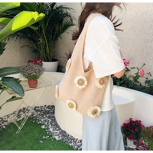 Detail of 3D knit daisies and colorful beads on a beige summer woven shoulder bag