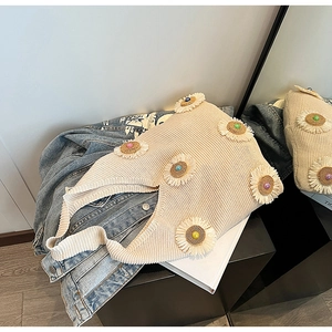 Detailed close-up of beige knitted tote bag with 3D daisy flower accents and colorful beads