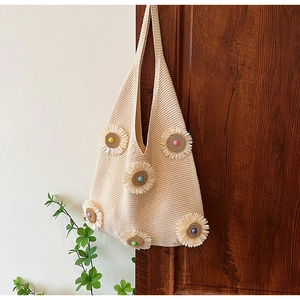 Close-up of knit tote bag with 3D floral accents and colorful bead centers