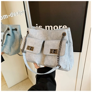 Light blue quilted chain tote bag with vintage turn-lock front pockets and denim texture