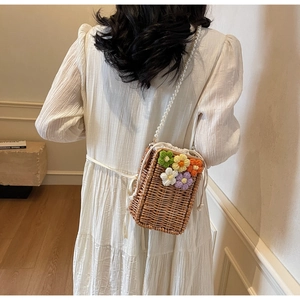 Sac seau en paille avec fleurs tricotées et poignée en perles élégante en détail