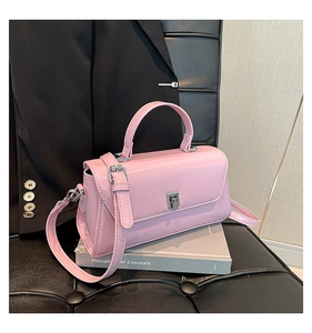 Close-up of pink glossy patent leather bag featuring silver metal twist lock closure