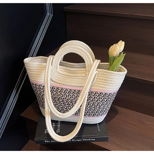 Détail du sac tissé aux couleurs contrastées avec poignées anneaux sur bois