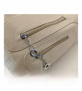 Detail showing cream lychee grain leather texture and double silver metal chain zippers