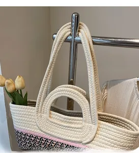 Détail du sac tissé montrant des rayures roses et un motif géométrique bicolore