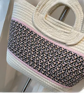 Gros plan du sac tissé bicolore montrant la maille beige et les motifs ondulés