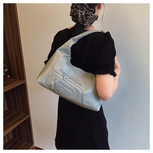 Close-up of silver-grey leather shoulder bag with double zippers and metal rings