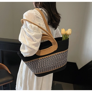 Détail d'un grand sac cabas tissé avec textures noir et rose et des poignées en corde