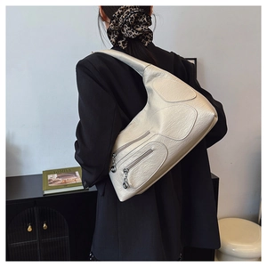 Close-up of cream nylon shoulder bag featuring lychee texture and silver zipper details