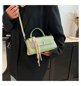 Detail of avocado green patent leather crossbody bag with a colorful decorative silk scarf
