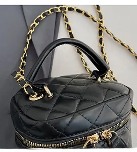 Detail view of black quilted leather texture with gold metal chain and zipper closure