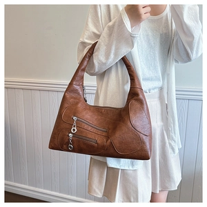 Detail of vintage brown nylon shoulder bag with silver ring zippers and metal accents