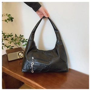 Detailed shot of retro black nylon tote bag featuring decorative zippers and silver chain