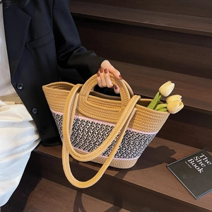 Gros plan détaillé du sac cabas tissé avec accents roses et motifs géométriques