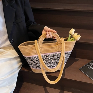 Détail d'un sac cabas tissé avec motifs géométriques et doubles poignées rondes