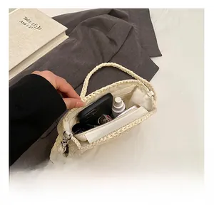 Close-up of the spacious interior of the cream straw woven bag with a secure zipper closure