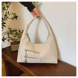 Detail of cream nylon hobo bag featuring double zippers and round metallic puller