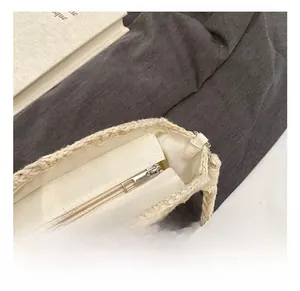 Detail of the high-quality silver metal zipper and woven texture on a beige straw bag