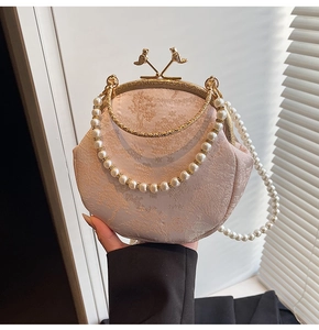 Close-up of vintage shell evening bag with bird clasps and pearl chain details