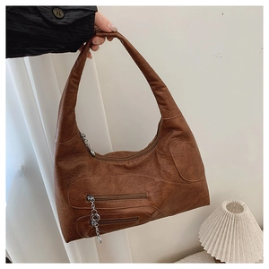 Close-up of brown vintage hobo bag featuring decorative stitching and silver chain zippers