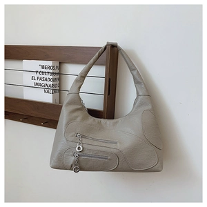 Detail of dark grey textured nylon hobo bag featuring silver metal zippers and spacious base