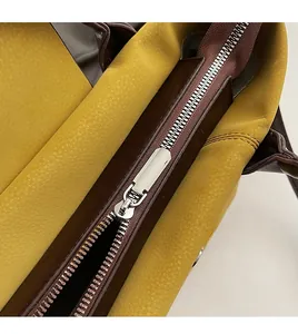 Close-up of smooth silver zipper on a contrast color pebbled leather tote bag