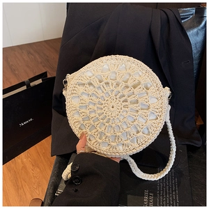 Close-up of the intricate hollow-out radial pattern on a cream woven straw bag