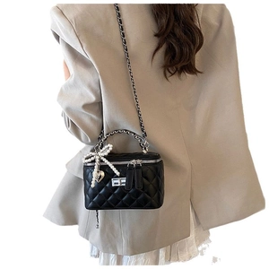 Elegant black quilted vanity bag with pearl bow charm and silver chain strap for women