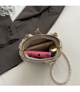 Detailed interior of pearl shell evening bag showing spacious storage for phone and makeup