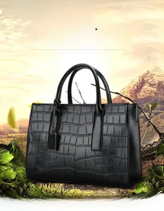 Close-up of the elegant black crocodile pattern and metallic logo tag on a tote bag