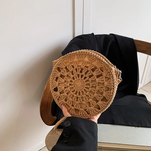 Handcrafted round straw crossbody bag with bohemian tassel and hollow-out woven pattern