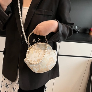 Vintage embroidered shell bag with gold mountain pattern, pearl strap, and bird clasps
